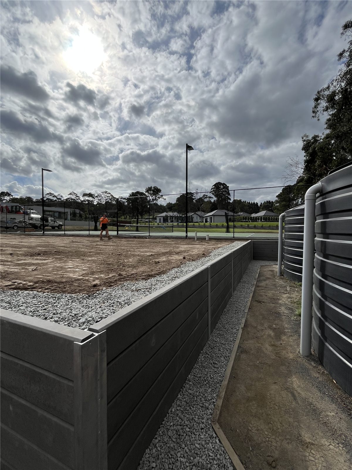 Charcoal retaining wall beside installed water tanks